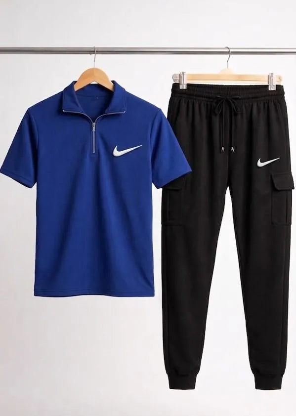 Blue Nike shirt and black Nike pants on hangers against a white background